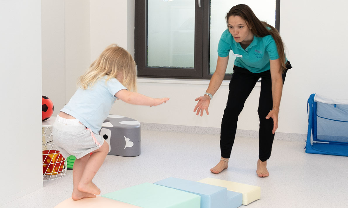 Mini Maxi Med – interdisziplinäre Therapie Mini Maxi Med Physiotherapeutin im spielerische Bewegungsangebot mit Kind