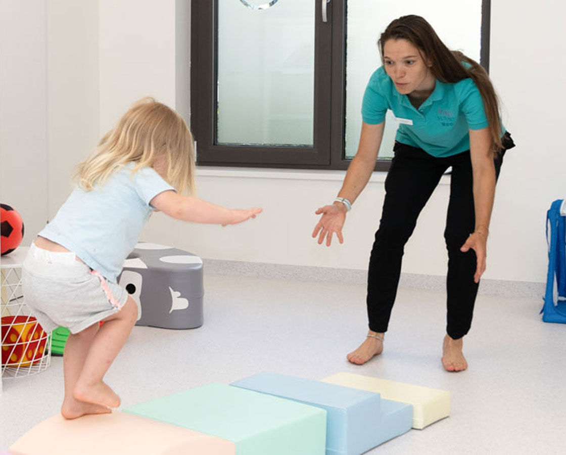 Mini Maxi Med – interdisziplinäre Therapie Mini Maxi Med Physiotherapeutin im spielerische Bewegungsangebot mit Kind