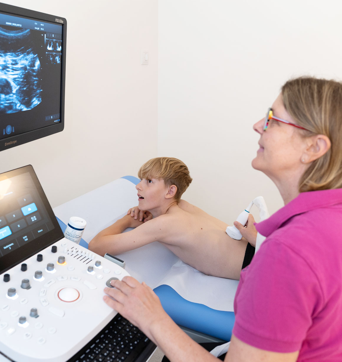 Kinderärztin bei Ultraschalluntersuchung mit Jugendlichem