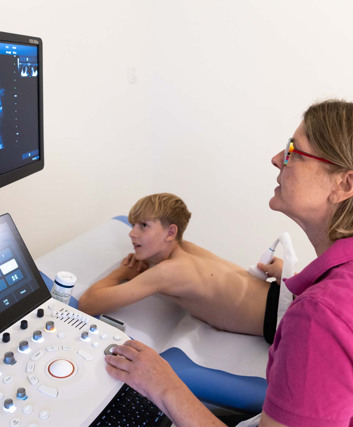 Kinderarzt Leistungen für Jugendliche Kinderärztin bei Ultraschalluntersuchung mit Jugendlichem